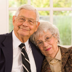 elderly couple smiling and embracing